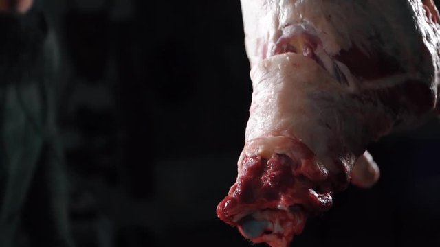 Moscow, Russia, 06.05.2020: Aggressively chopping meat with a knife in a dark room