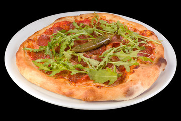 Tasty pizza pepperoni with tomato sauce, salami, arugula, hot pepper in a plate, isolated on black background.