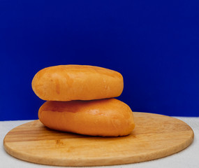 Baked pies on a wooden board on a blue background. Food photo, copy space. Still life.