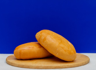 Two pies on a wooden board on a blue background. Food photo, copy space. Still life.