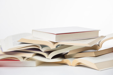 Lots of open books stacked isolated on white background