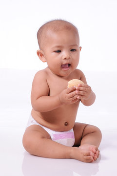 A Little Cute Asian Baby girl wearing diaper open her mouth ready eating biscuit