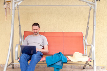 handsome business man working from his house porch during the coronavirus outbreak. Covid-19 adjusting to new lifestyle.