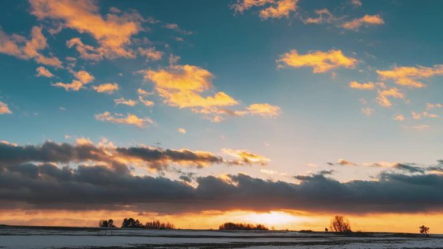 Winter Meadow Field At Evening Sunset. Natural Bright Dramatic Sky Colours Above Countryside Snowy Landscape. Agricultural Landscape In January. Time Lapse Time-lapse Timelapse