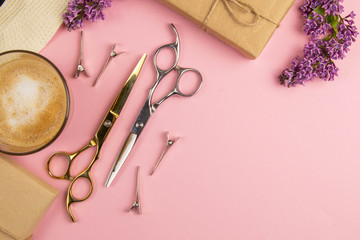 Hairdresser tools - scissors, combs and pink flowers with coffe on pink background. Beauty concept....
