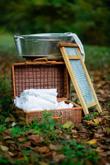 Wicker basket with clean linen. A washboard with a metal basin. Things of the past.