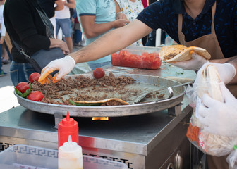 Traditional Turkish shawarma meat being prepared with red tomatoes