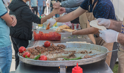 Traditional Turkish shawarma meat being prepared with red tomatoes