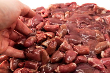 The hand mixes the chicken liver and heart and prepares for cooking