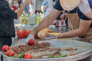 Traditional Turkish shawarma meat being prepared with red tomatoes