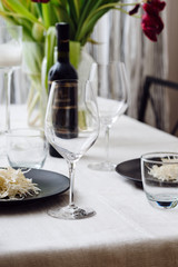 Photo of a home cozy supper with glass of red wine and salad from fresh eco vegetables on black plate indoors