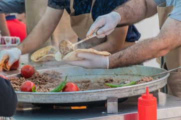 Traditional Turkish shawarma meat being prepared with red tomatoes