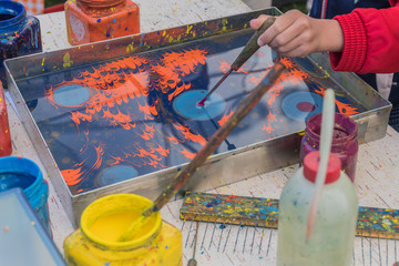 Kid child learning the turkish water painting named "Paper marbling"