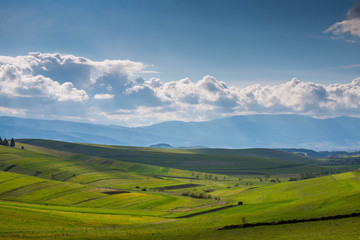 Beautiful green valley at springtime, gathering stormclouds , agricultural fields in Transylvania, Romania.