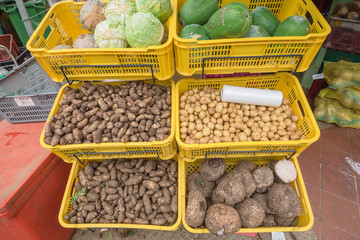 Fresh produces, fruits and root crops in yellow plastic crates at vegetable stall in Little India, Singapore