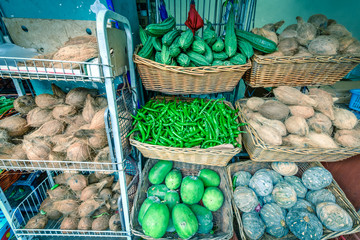 Colorful vegetable stall in Little India, Singapore with luffa acutangula, coconut, acorn squash