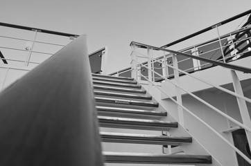 Empty staircase or stairs on cruiseship or cruise ship liner with metal railing and wooden handrail