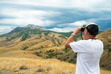Man In Cap Looks At Mountains In Crimea, Russia.
