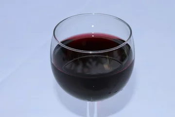 Fotobehang Verre de vin rouge dans un verre à vin transparent sur une nappe blanche - Département du Rhône - France © ERIC