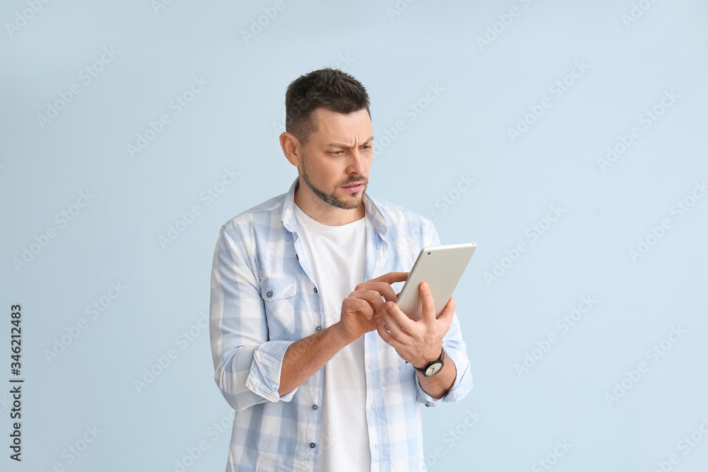 Aufkleber handsome man with tablet computer on color background