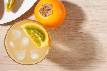 glass with juice and slices of lulo fruit, on the table