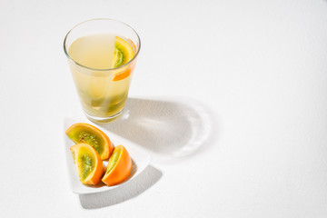 glass with juice and slices of lulo fruit, on the table