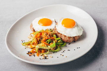 baked eggs and burgers meal with roasted vegetables