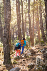 Fototapeta premium Two girls with backpacks walk in the woods.