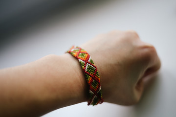 Hand close with knitted colored bracelets