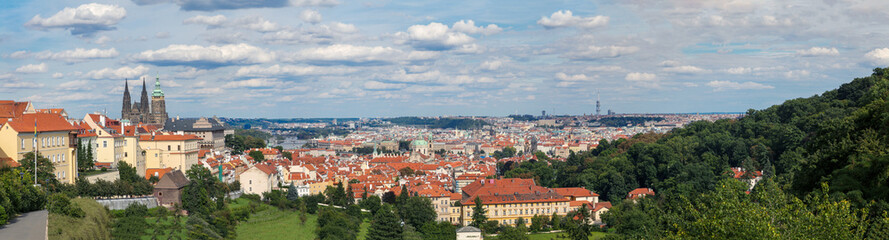 Naklejka na ściany i meble Panoramic view onto traditional red roofs in old town Prague and the river Vltava.