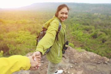Couples who enjoy hiking, walking hand in hand to go ahead.