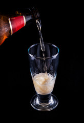 vaso llenándose de cerveza sobre fondo oscuro