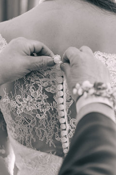 Mother's hands Botton the brides dress before the wedding. Selective focus