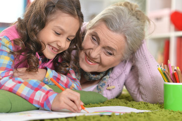 Portrait of grandmother and granddaughter drawing together