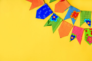 Multicolored fabric flags on a yellow background. Decorations for the holiday. Flatlay with space...