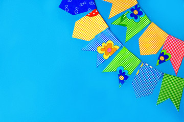Multicolored fabric flags on a blue background. Decorations for the holiday. Flatlay with space for text