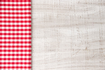 Red cotton checkered fabric side view on a wooden table