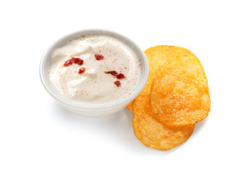 Bowl with tasty sour cream and potato chips on white background