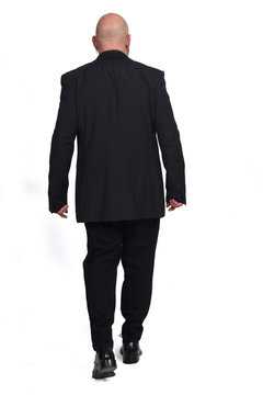 full portrait of a man from behind walking on white