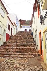 Calle de Silves construida en una pendiente salvada con una gran escalera de piedra. Silves, Algarve, Portugal.