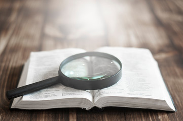 Open Bible. On the table. Holy Bible, Scripture. Magnifier