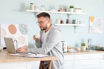 Young man with laptop working at home