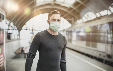 young man in mask in railway station