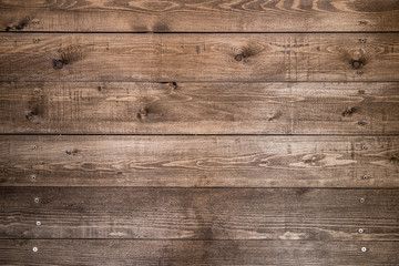 Old brown wood background made of dark natural wood in grunge style. The view from the top. Natural raw planed texture of coniferous pine. The surface of the table to shoot flat lay. Copy space.