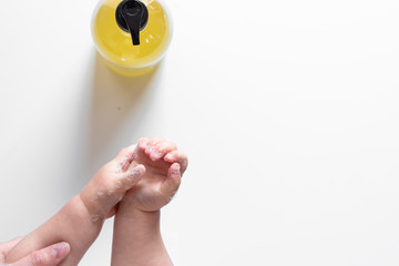 baby child washing hands with antibacterial liquid soap dispenser. Coronavirus (Covid-19) preventive measures top view concept - top view - flat lay - banner