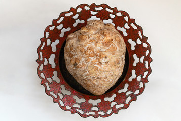 Whole celery root on a metal plate with an ornament.