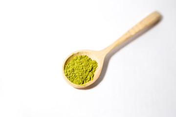 Green powder of Japanese matcha tea in a teaspoon. Matcha on a white background, isolated