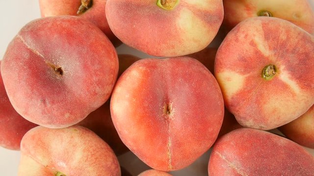 Flat peaches on a plate.