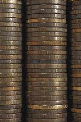Background or wall from piles and edges of yellow brass coins close-up. 10 ten Russian rubles. Dark vertical textured backdrop or wallpaper for economic, banking, financial, monetary topics. Macro