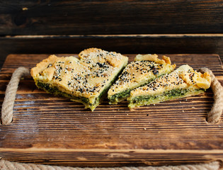 Homemade spinach french pie on a white wooden board